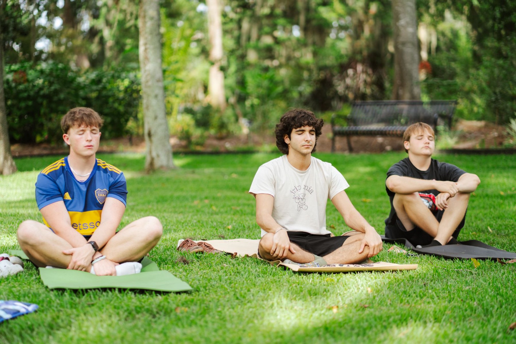 Three Club108 participants meditating outdoors